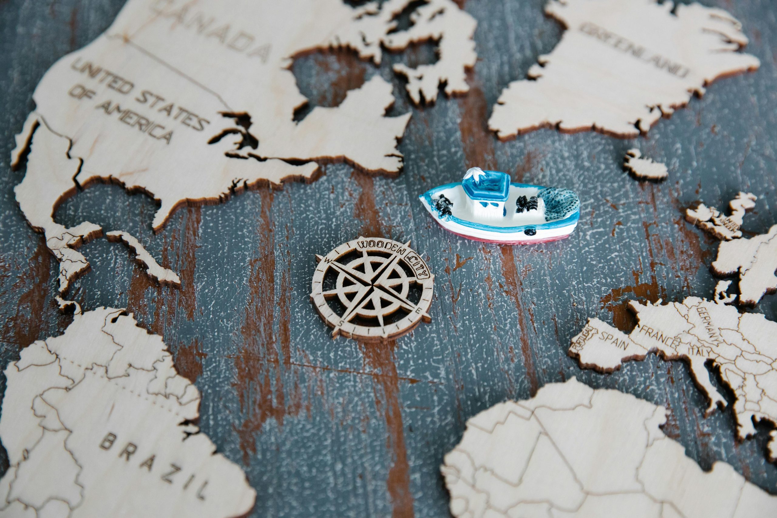 Discover a wooden world map with a small toy boat, evoking global exploration.